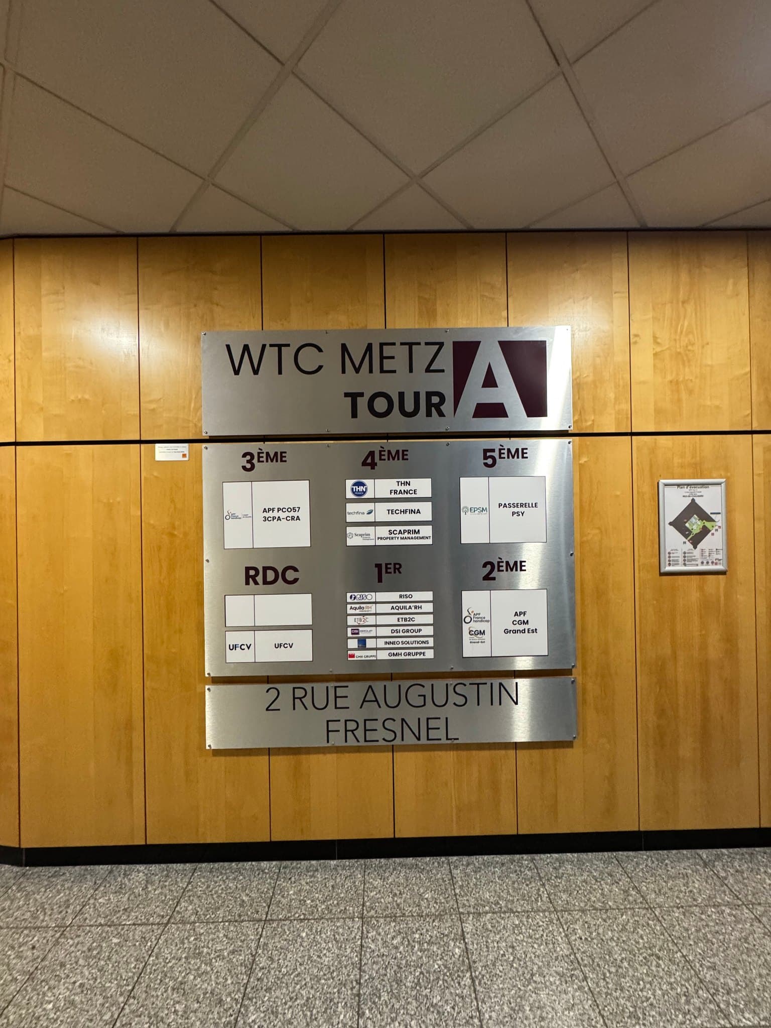 Signalétique intérieure en Dibond alu brossé installée dans le hall du World Trade Center Metz, avec répartition des entreprises par étage.