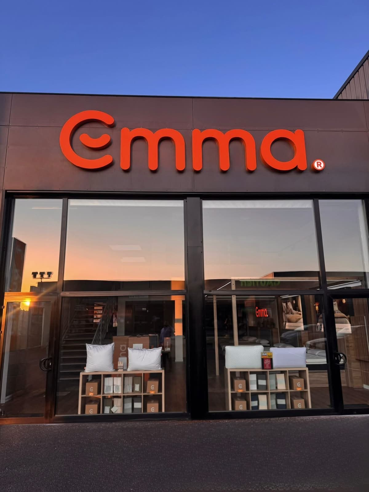Enseigne boîtier lumineuse extérieure Emma, installée en façade du showroom pour renforcer la visibilité de la marque.
